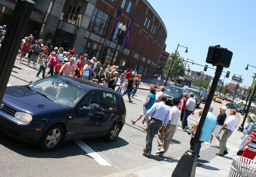 A picture of pedestrians crossing a busy intersection.