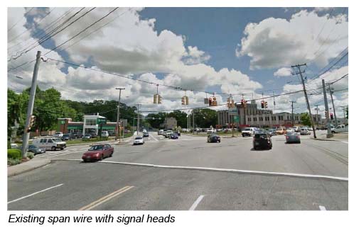 This photo shows traffic signal heads that are hanging from an existing overhead wire.
